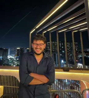 Jash Parmar smiling on a rooftop at night